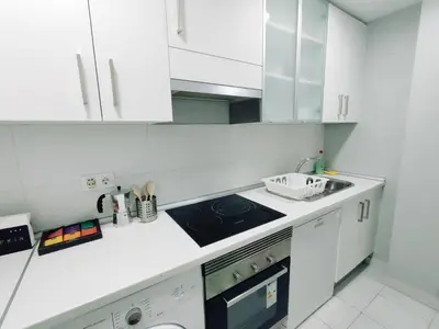 a white kitchen with a sink and a stove at Alonso Cano Playa in Cádiz