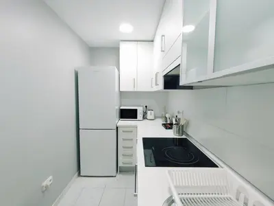 a white kitchen with a refrigerator and a sink at Alonso Cano Playa in Cádiz