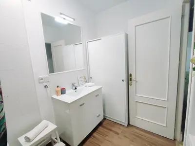 a white bathroom with a sink and a mirror at Alonso Cano Playa in Cádiz