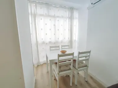 a white table and chairs in a room with a window at Alonso Cano Playa in Cádiz