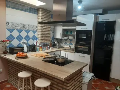 a kitchen with a counter with stools in it at Piso de dos dormitorios en el centro de Sanlúcar de Barrameda in Sanlúcar de Barrameda