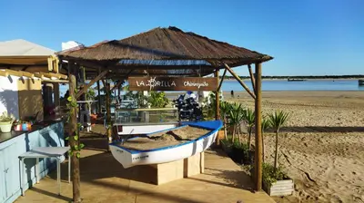 a small boat under a hut on the beach at Piso de dos dormitorios en el centro de Sanlúcar de Barrameda in Sanlúcar de Barrameda
