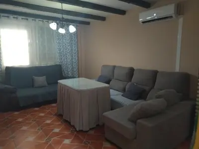 a living room with a couch and a table at Piso de dos dormitorios en el centro de Sanlúcar de Barrameda in Sanlúcar de Barrameda