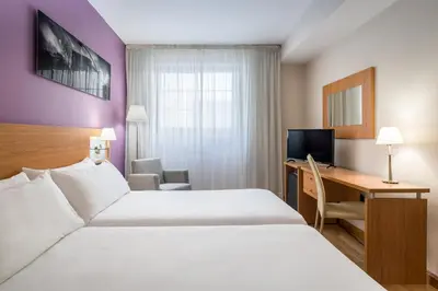 a hotel room with two beds and a desk at Hotel Jerez Centro in Jerez de la Frontera