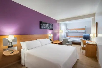 a bedroom with a white bed and a purple wall at Hotel Jerez Centro in Jerez de la Frontera