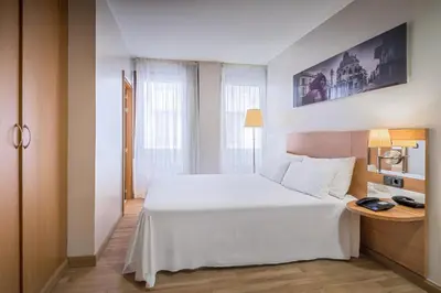a bedroom with a white bed and a desk at Hotel Jerez Centro in Jerez de la Frontera