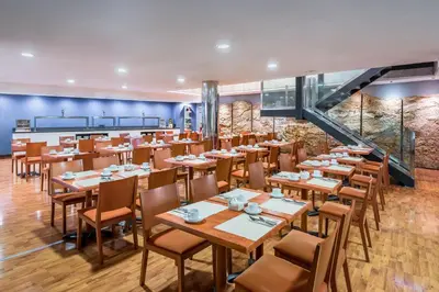 a dining room with wooden tables and chairs at Hotel Jerez Centro in Jerez de la Frontera