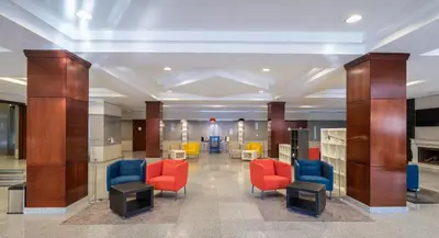 a lobby with red and blue chairs and tables at Hotel Jerez Centro in Jerez de la Frontera