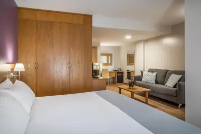 a hotel room with a bed and a couch at Hotel Jerez Centro in Jerez de la Frontera