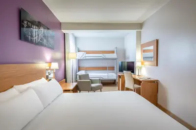 a hotel room with a bed and a desk and a bedroom at Hotel Jerez Centro in Jerez de la Frontera
