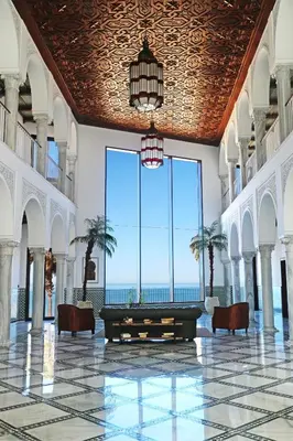 a lobby with a table and chairs and a view of the ocean at Apartamentos Turísticos La Baílla in Rota