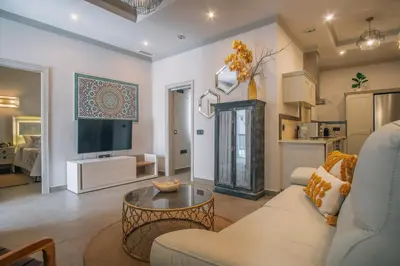 a living room with a couch and a tv at Apartamentos Turísticos La Baílla in Rota
