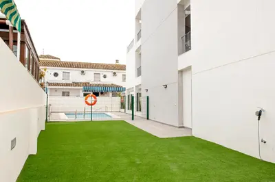 a courtyard with green grass in a building at Arenas de Sanlúcar in Sanlúcar de Barrameda