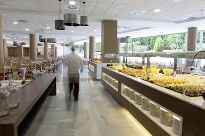 a person walking down a aisle in a grocery store at ALEGRIA Costa Ballena Aquafun in Costa Ballena