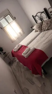 a bedroom with a bed with a red blanket at Apto MANAMAR - Entre centro y playa - Parking privado gratis in Sanlúcar de Barrameda