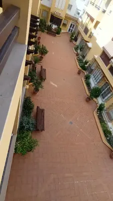 an empty courtyard of a building with benches at Apto MANAMAR - Entre centro y playa - Parking privado gratis in Sanlúcar de Barrameda