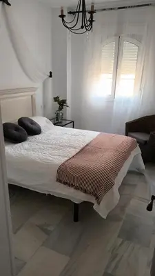 a bedroom with a large bed with pillows on it at Apto MANAMAR - Entre centro y playa - Parking privado gratis in Sanlúcar de Barrameda