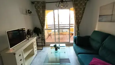 a living room with a couch and a tv at Apto MANAMAR - Entre centro y playa - Parking privado gratis in Sanlúcar de Barrameda