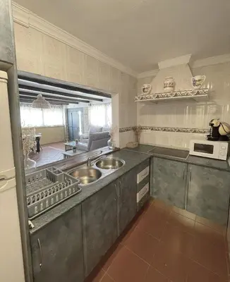 a kitchen with two sinks and a microwave at RURAL VILLA ANGELS in Arcos de la Frontera
