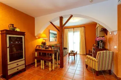 a living room with orange walls and an archway at Apartahotel La Espadaña in Rota
