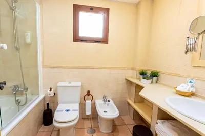 a bathroom with a toilet and a sink and a shower at Apartahotel La Espadaña in Rota