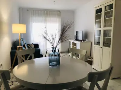 a living room with a table with a vase on it at Sanlúcar Playa de las Piletas in Sanlúcar de Barrameda