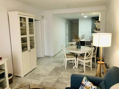 a living room with a table and chairs at Sanlúcar Playa de las Piletas in Sanlúcar de Barrameda