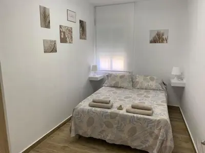 a bedroom with a bed with two pillows on it at Precioso apartamento con patio/terraza Zona centro in Jerez de la Frontera