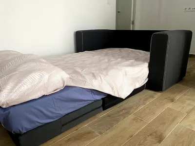 a bed with a black frame in a room at Precioso apartamento con patio/terraza Zona centro in Jerez de la Frontera