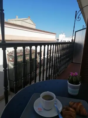 a cup of coffee and croissants on a table on a balcony at Hotel Doña Blanca in Jerez de la Frontera