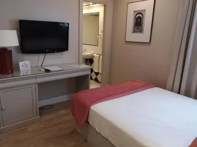 a bedroom with a bed and a tv on a desk at Hotel Doña Blanca in Jerez de la Frontera