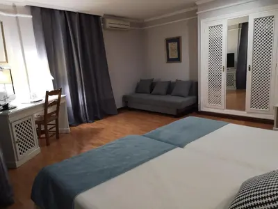 a bedroom with a bed and a couch in it at Hotel Doña Blanca in Jerez de la Frontera