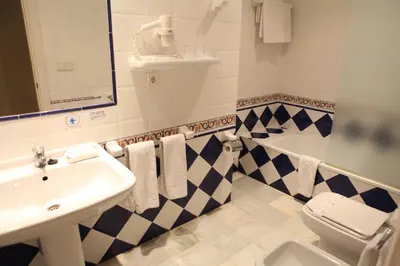 a bathroom with a sink and a toilet and a tub at Hotel Doña Blanca in Jerez de la Frontera