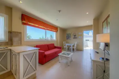 a living room with a red couch and a table at Apartamentos Piedramar in Conil de la Frontera