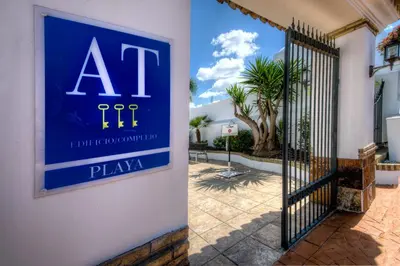a blue sign on the side of a building with a gate at Apartamentos Piedramar in Conil de la Frontera