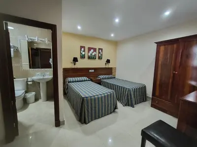 a bathroom with two beds and a sink at Hotel Nova Centro in Jerez de la Frontera