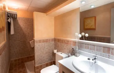 a bathroom with a toilet and a sink at Apartamentos Turísticos Los Patios in Rota