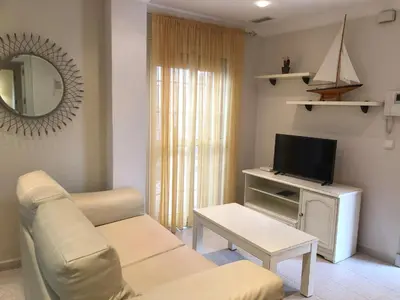 a living room with a couch and a tv at Apartamentos Turísticos Los Patios in Rota