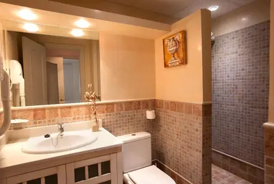 a bathroom with a sink and a toilet and a mirror at Apartamentos Turísticos Los Patios in Rota