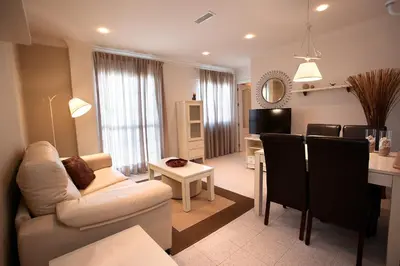 a living room and kitchen with a couch and a table at Apartamentos Turísticos Los Patios in Rota