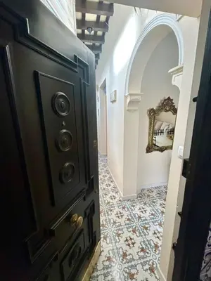 a hallway with a black door and a tile floor at GATU Casa Lola , 