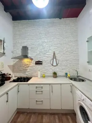 a kitchen with a sink and a brick wall at GATU Casa Lola , 