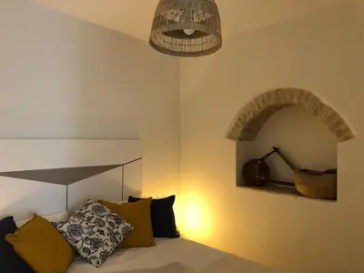 a row of pillows sitting on a couch with a mirror at Casa del Olivo by Casitasconencantoes in Medina Sidonia