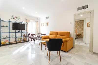 a living room with a couch and a dining room at Allo Apartments Porvenir Centro 1 Habitación in Jerez de la Frontera