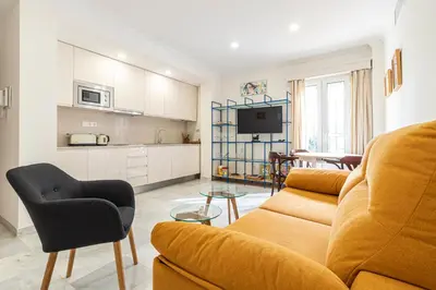 a living room with a couch and a kitchen at Allo Apartments Porvenir Centro 1 Habitación in Jerez de la Frontera