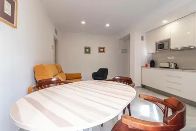 a dining room with a white table and chairs at Allo Apartments Porvenir Centro 1 Habitación in Jerez de la Frontera
