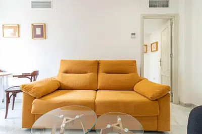 a brown couch in a living room with a table at Allo Apartments Porvenir Centro 1 Habitación in Jerez de la Frontera