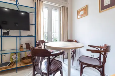 a dining room with a table and chairs and a tv at Allo Apartments Porvenir Centro 1 Habitación in Jerez de la Frontera