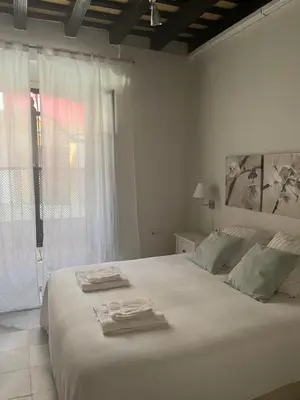 a white bedroom with a large bed with towels on it at Jardin Bizcocheros in Jerez de la Frontera