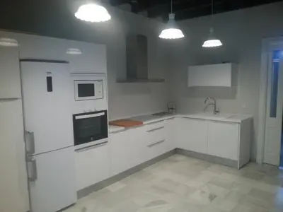 a kitchen with white cabinets and a sink and a microwave at Jardin Bizcocheros in Jerez de la Frontera